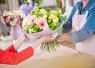 Florist handing over a colorful mixed bouquet