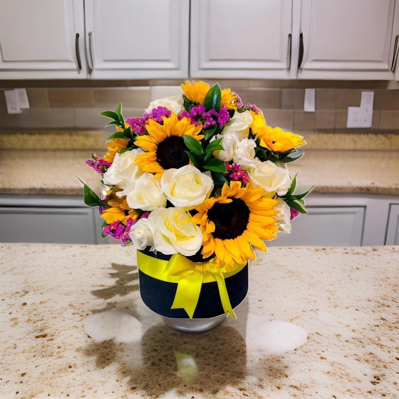 Sunflowers and white roses in navy vase with yellow ribbon